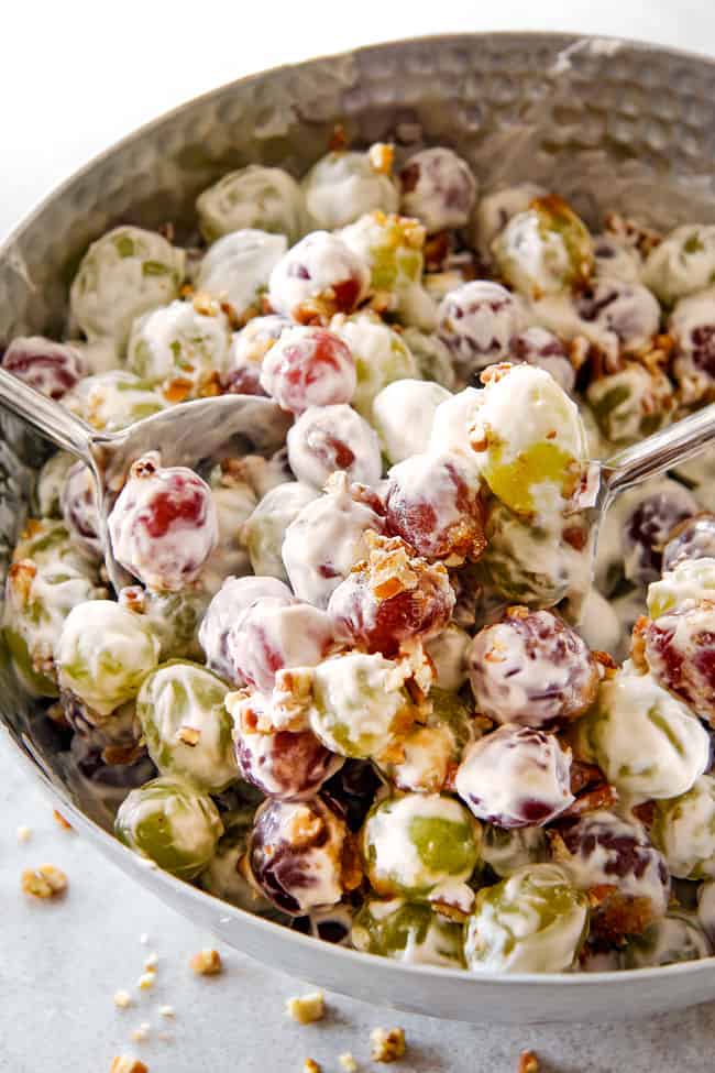 creamy grape salad in a silver bowl with brown sugar and pecans with cream cheese dressing