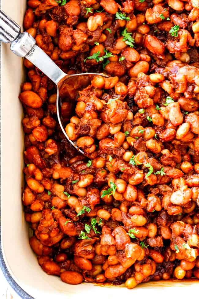 Homemade Baked Beans in a casserole dish with a silver spoon