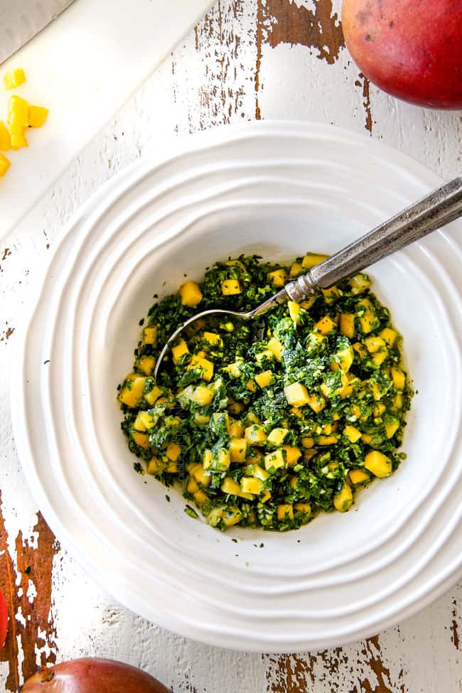 top view of chimichurri in a white bowl with a silver spoon for Chimichurri Steak