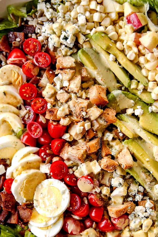 up close top view of Cobb salad with lettuce, hard boiled eggs, avocados, bacon, tomatoes and blue cheese