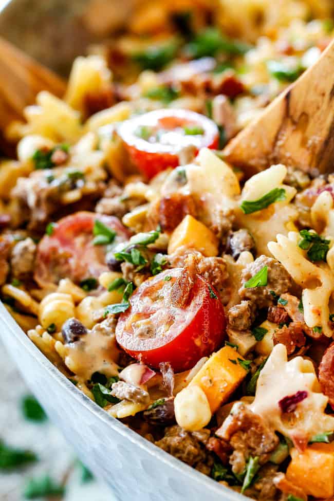 up close of Cowboy Pasta Salad with ground beef, black beans, corn, tomatoes and barbecue sauce in a metal bowl