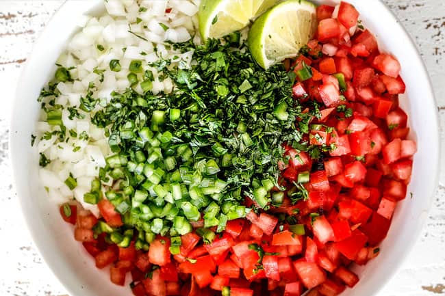 top view of tomatoes, cilantro, onions, jalapenos, lime juice in a white bowl for the authentic pico de gallo recipe