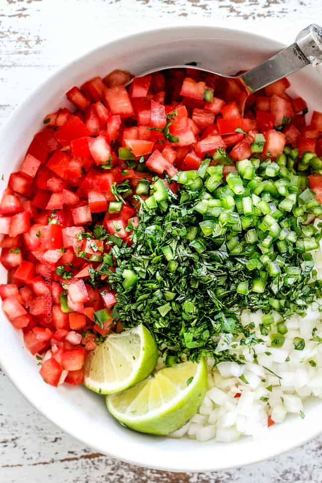 top view of tomatoes, cilantro, onions, jalapenos, lime juice in a white bowl for the best pico de gallo recipe