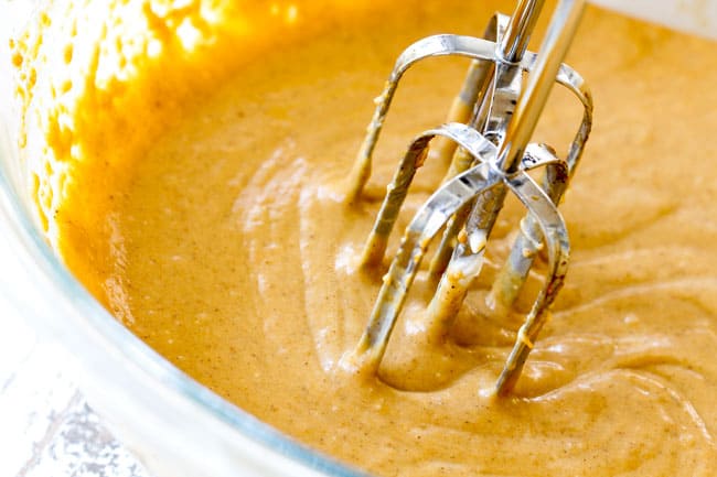 showing how to make pumpkin dip by mixing cream cheese, brown sugar, cinnamon in a glass bowl until smooth