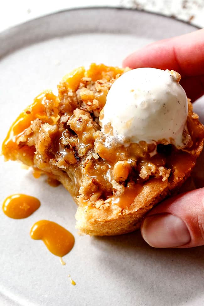 up close of salted caramel apple pie with ice cream and salted caramel with a bite taken out of it