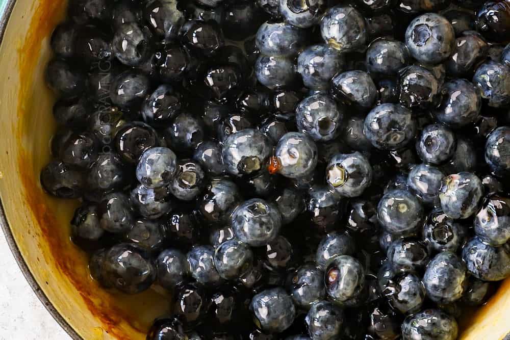 showing how to make best blueberry sauce by adding blueberries to a saucepan and simmering 