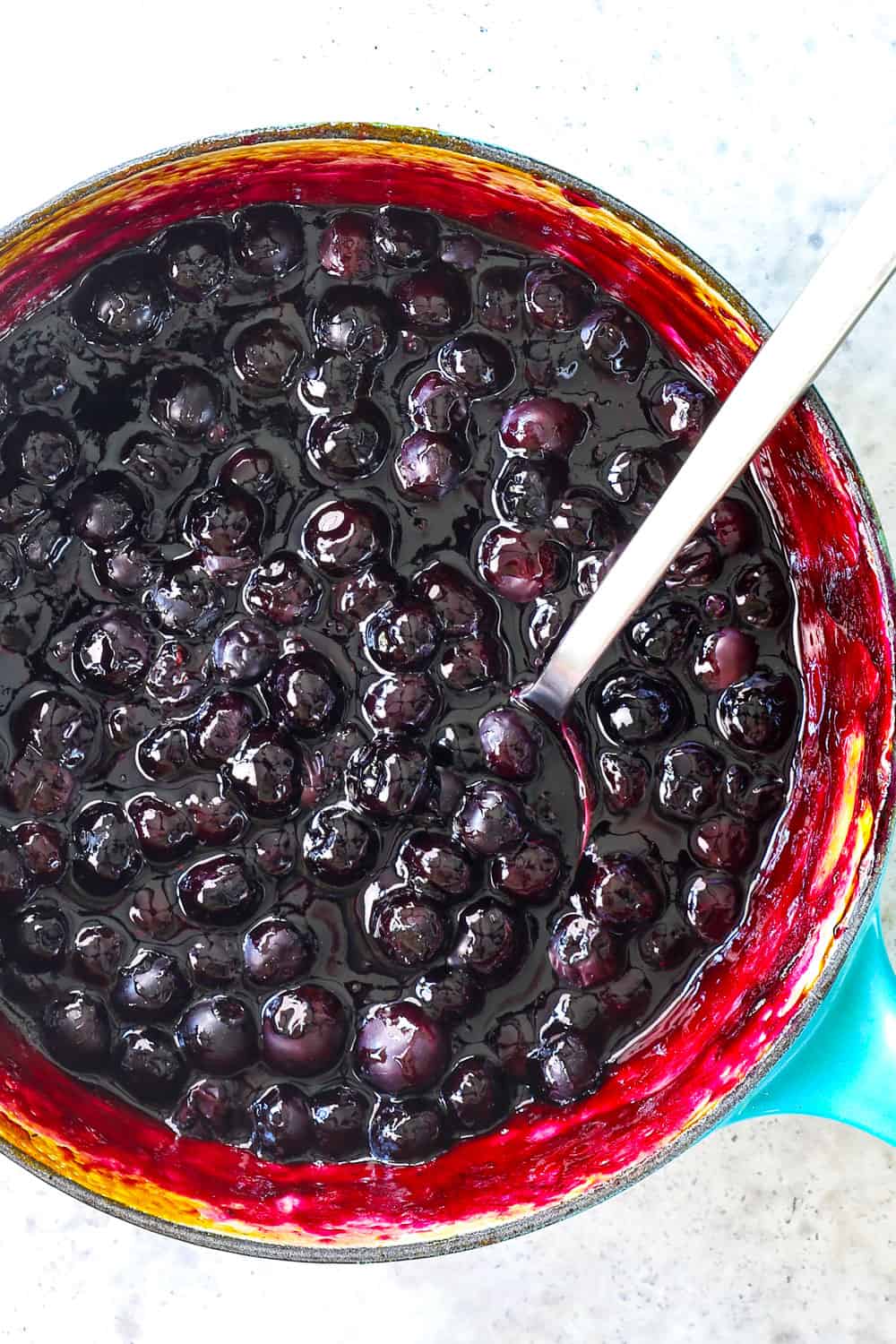 showing how to make fresh blueberry sauce by simmering blueberries with sugar, cornstarch, orange juice and lemon juice