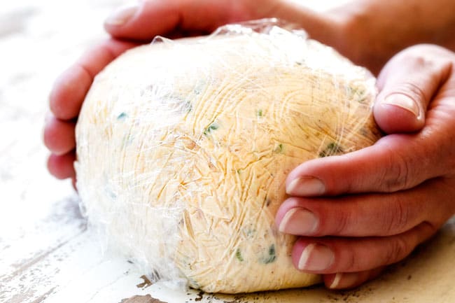 showing how to make Pineapple Cheese Ball by wrapping in plastic wrap and forming into a ball
