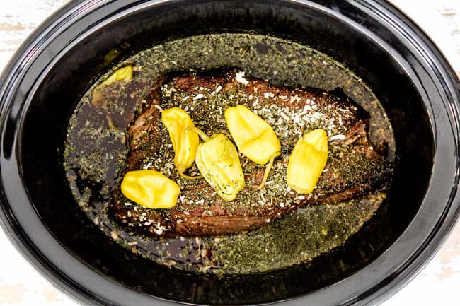 showing how to make Mississippi Pot Roast by adding beef and pepperoncinis to slow cooker