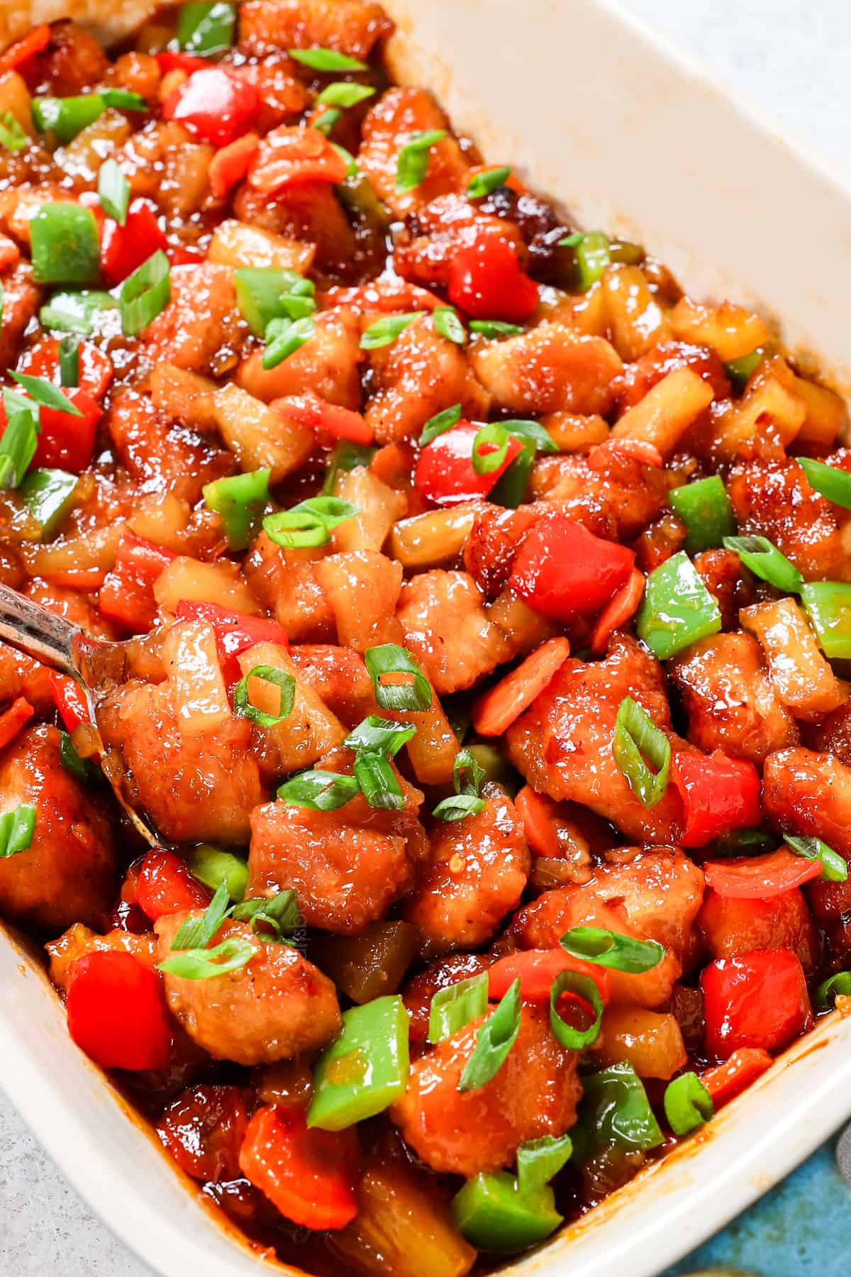 a spoonful of sweet & sour chicken showing its breaded and crispy texture