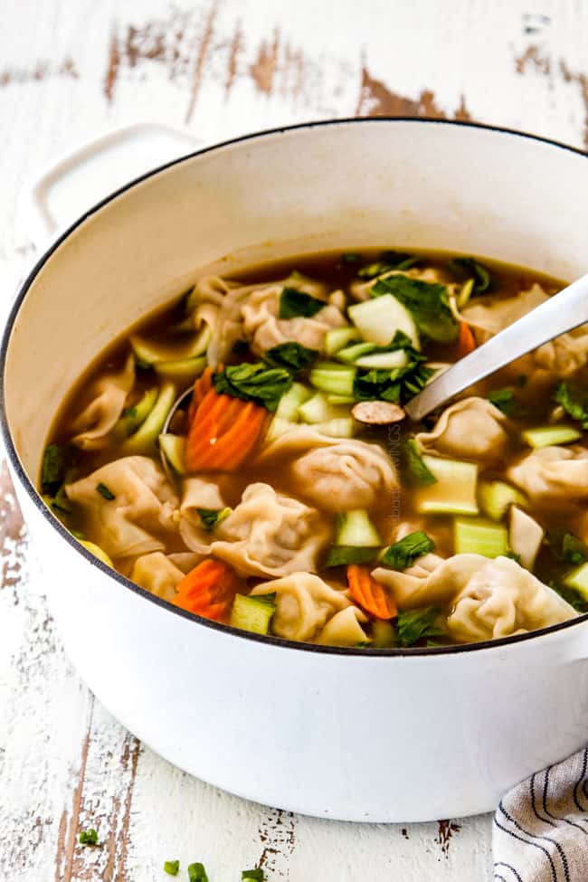 side view of easy wonton soup in a white soup pot
