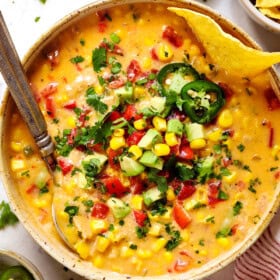 top view of chicken corn chowder recipe being served in a bowl showing how to garnish it with corn, jalapenos and cheese