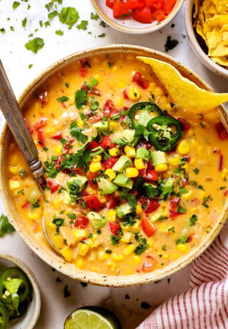 top view of chicken corn chowder recipe being served in a bowl showing how to garnish it with corn, jalapenos and cheese