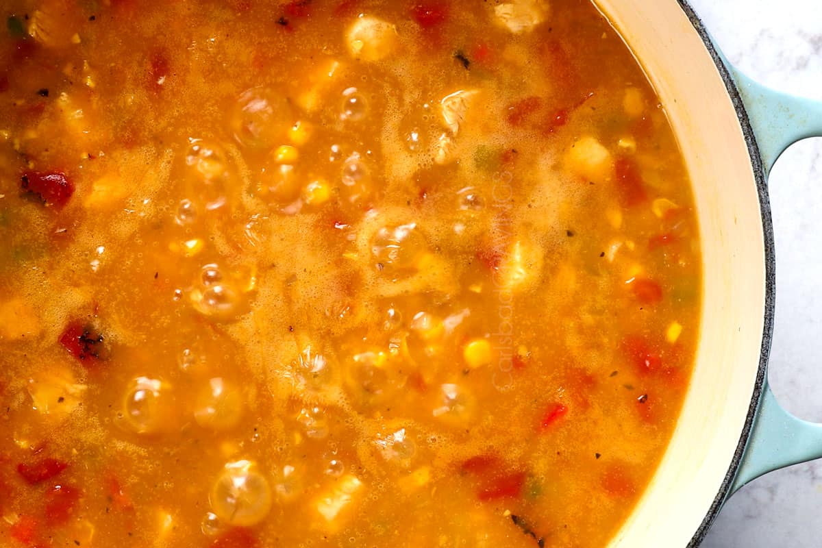 showing how to make chicken corn chowder by simmering the chowder to thicken.