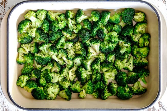 showing how to make easy chicken divan by adding steamed broccoli to a casserole dish in a single layer