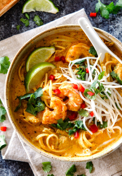top view of a bowl of laksa soup with noodles, chicken and shrimp