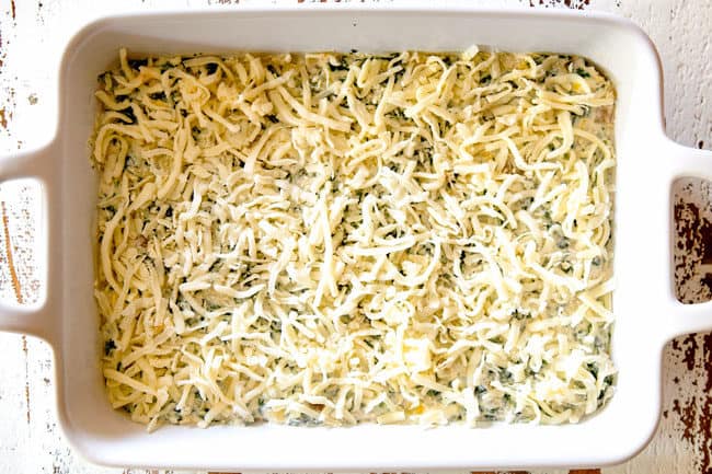 showing how to make best spinach artichoke dip by adding mozzarella cheese to the top of the dip before baking