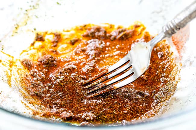 showing how to make Honey Mustard Chicken by whisking spices with olive oil in a glass bowl