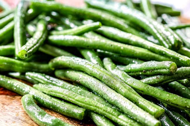 showing how to make Honey Mustard Chicken by seasoning green beans with olive oil, salt and pepper