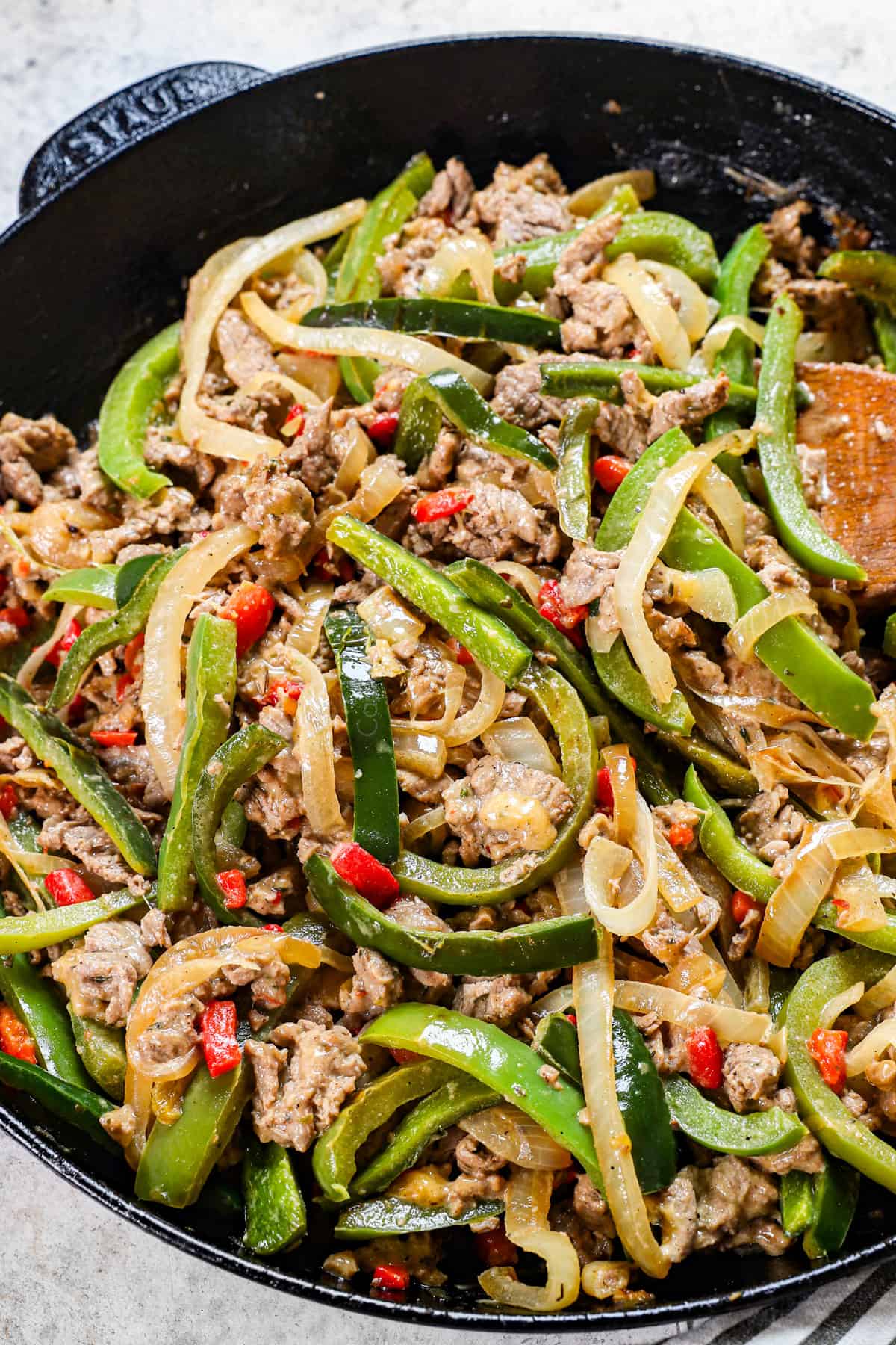 up close of Philly Cheesesteak meat mixture with thinly sliced beef, onions, pimentos, and melted cheese