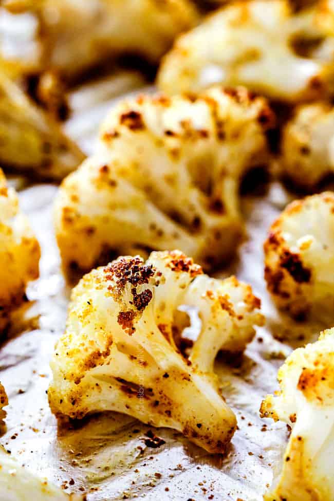 showing how to make roasted cauliflower by laying cauliflower on baking sheet and roasting until golden