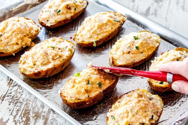 showing how to make twice baked potatoes by adding potato filling to potato shells