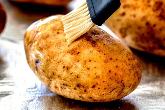 showing how to make twice baked potatoes by by brushing potatoes with olive oil