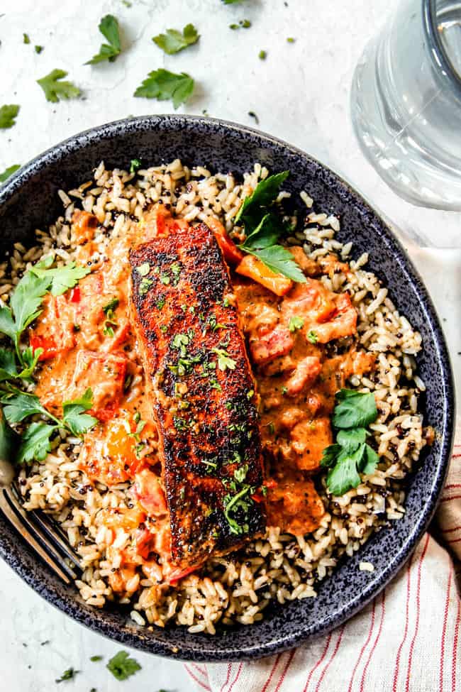 top view of easy blackened salmon on top of a bed of rice in a black bowl