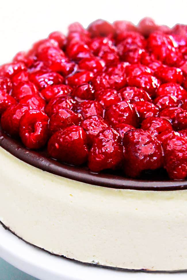 chocolate ganache cheesecake with a row of raspberries on top