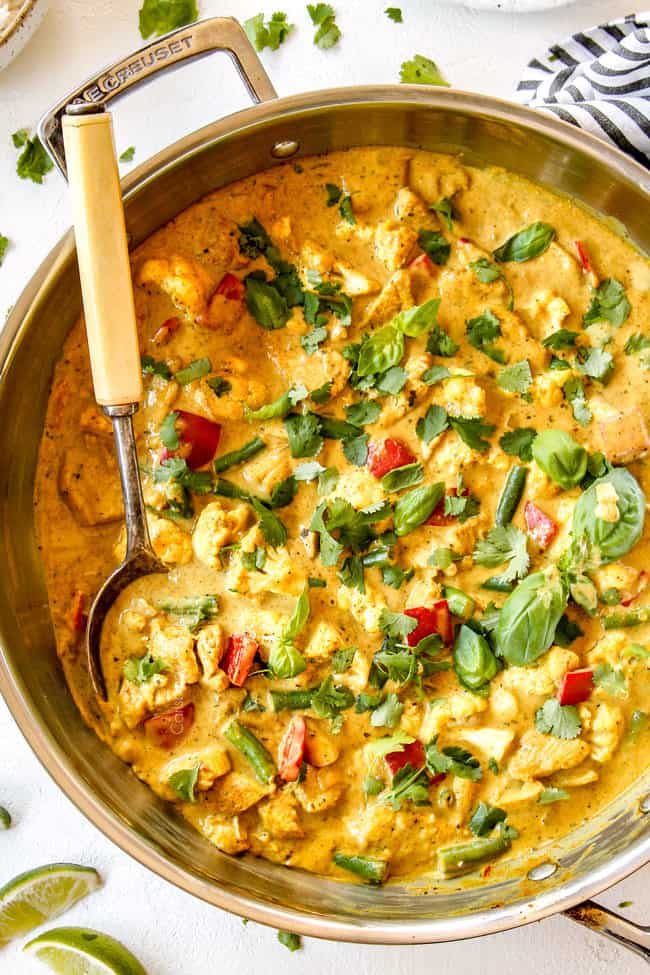 up close top view of creamy coconut curry chicken in a stainless steal skillet 