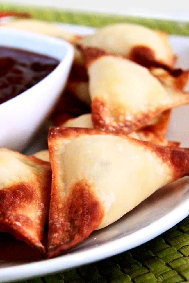 baked cream cheese wontons on a plate with dipping sauce