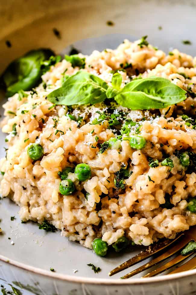 up close of a serving of spinach risotto recipe on a grey plate garnished with parsley