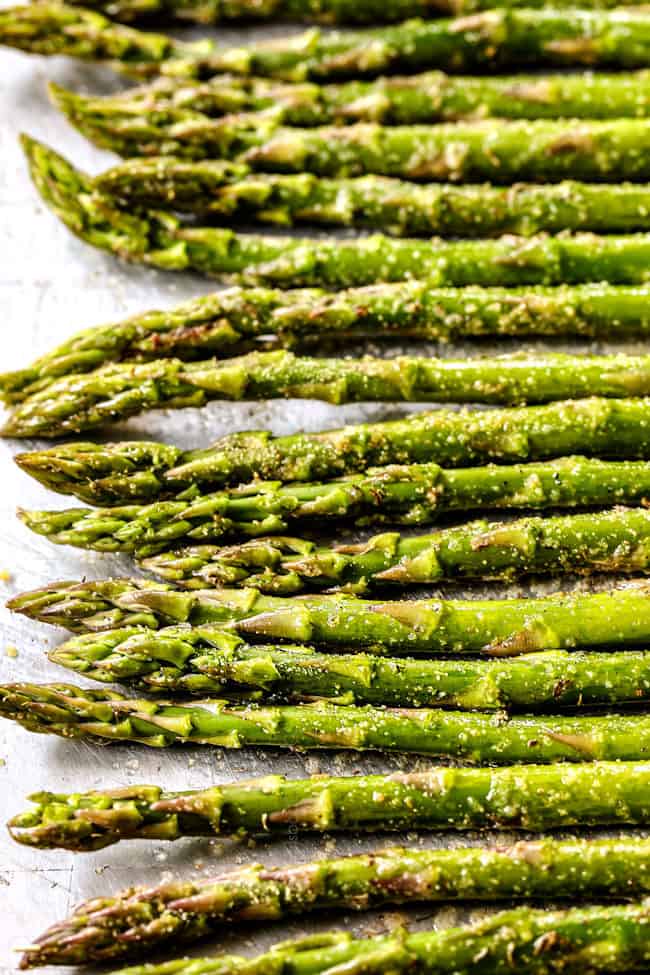 showing how to cook asparagus by seasoning it with salt, pepper and herbs before baking