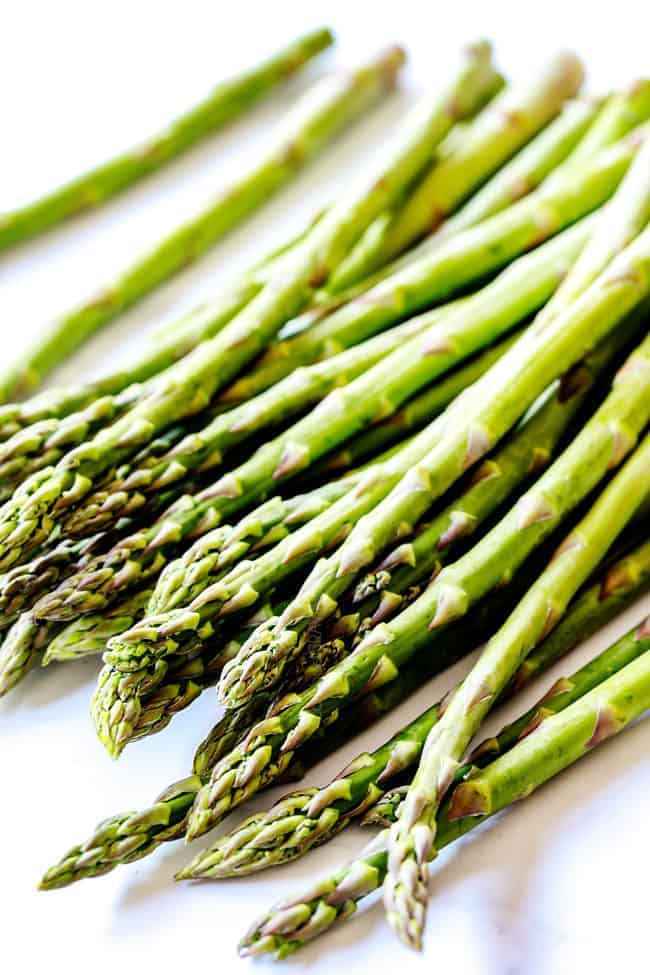 showing how to cook asparagus by trimming fresh asparagus