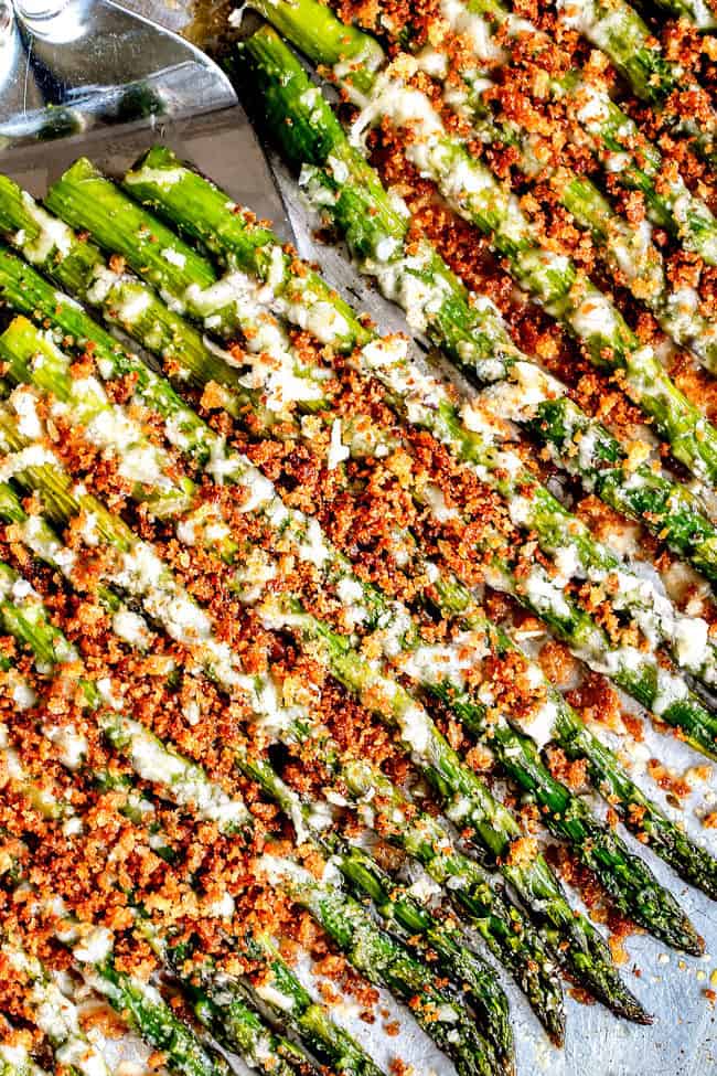 top view of baked asparagus with bacon being served with a spatula