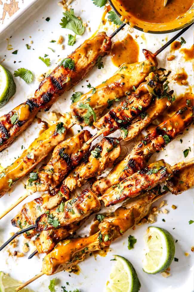 healthy chicken satay on wooden skewers garnished by cilantro