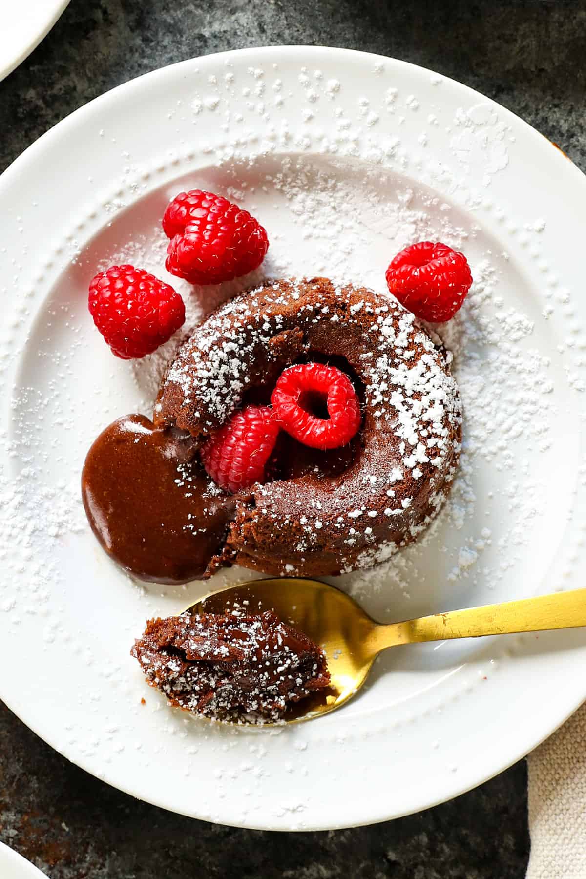 Top view of Chocolate Lava cake served with powdered sugar and raspberries 