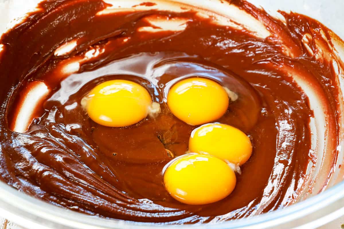 showing how to make chocolate lava cake recipe by adding eggs and egg yolks to the batter
