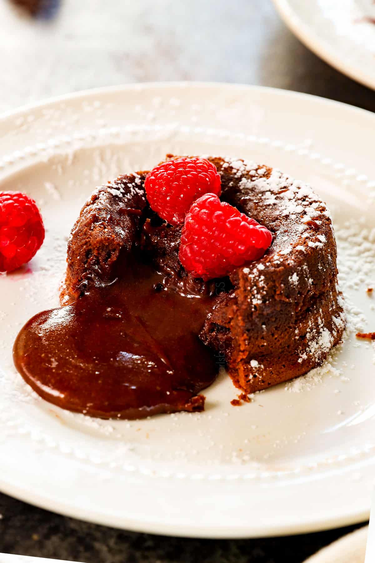 chocolate lava cake recipe on a white plate with an oozing chocolate center