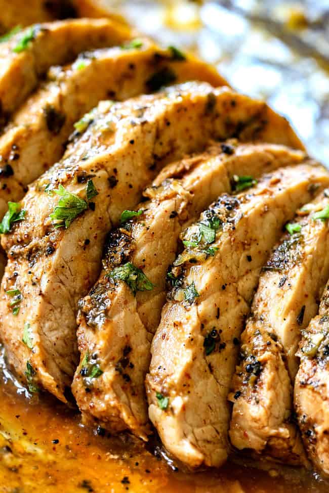 up close of juicy baked pork tenderloin recipe on a cutting board