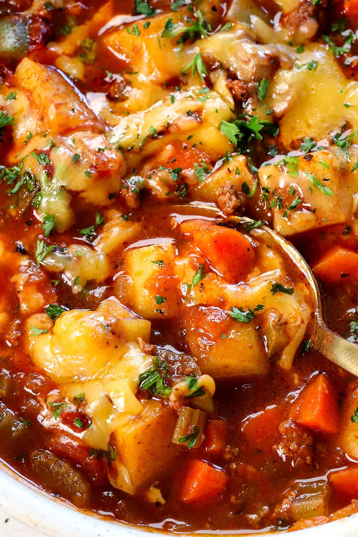 showing how to serve hamburger soup by adding cheese to melt