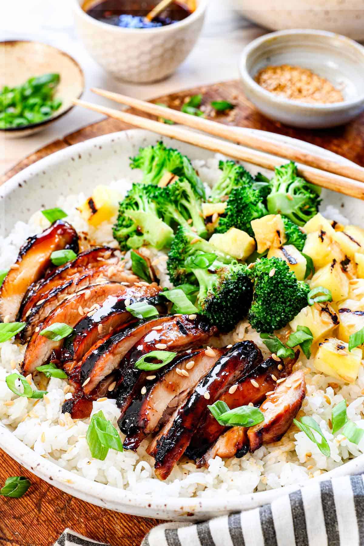 side view of teriyaki chicken thighs sliced on a plate showing how juicy they are