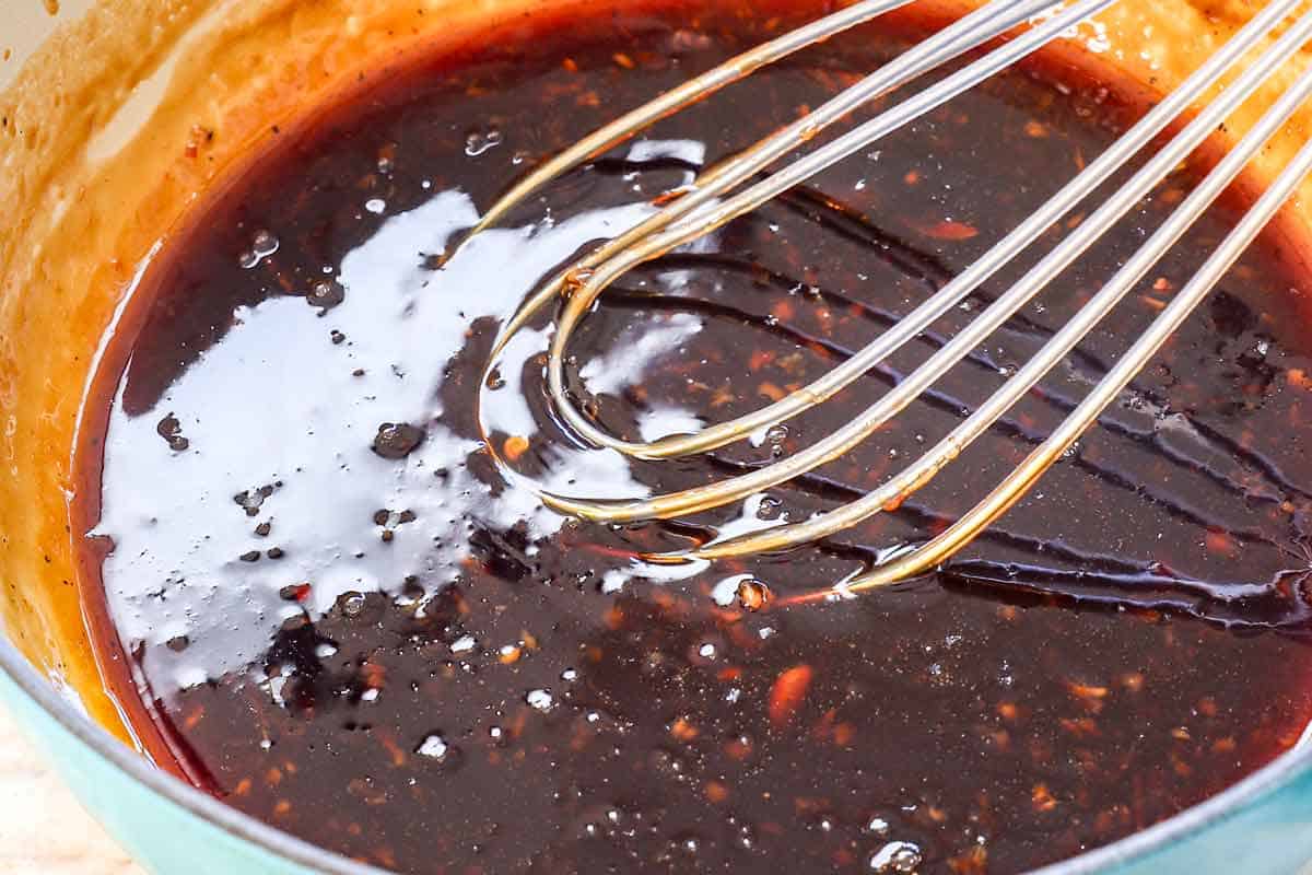 showing how to make teriyaki chicken by simmering the teriyaki glaze in a saucepan until thickened