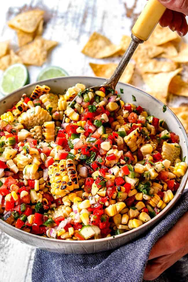showing how to make corn salsa by stirring ingredients in a bowl