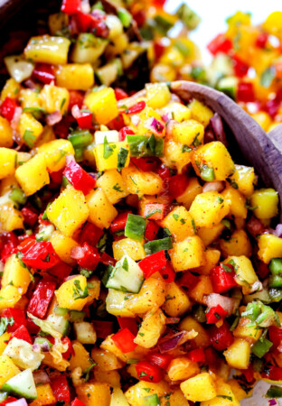 up close of two servings spoons scooping up mango salsa recipe
