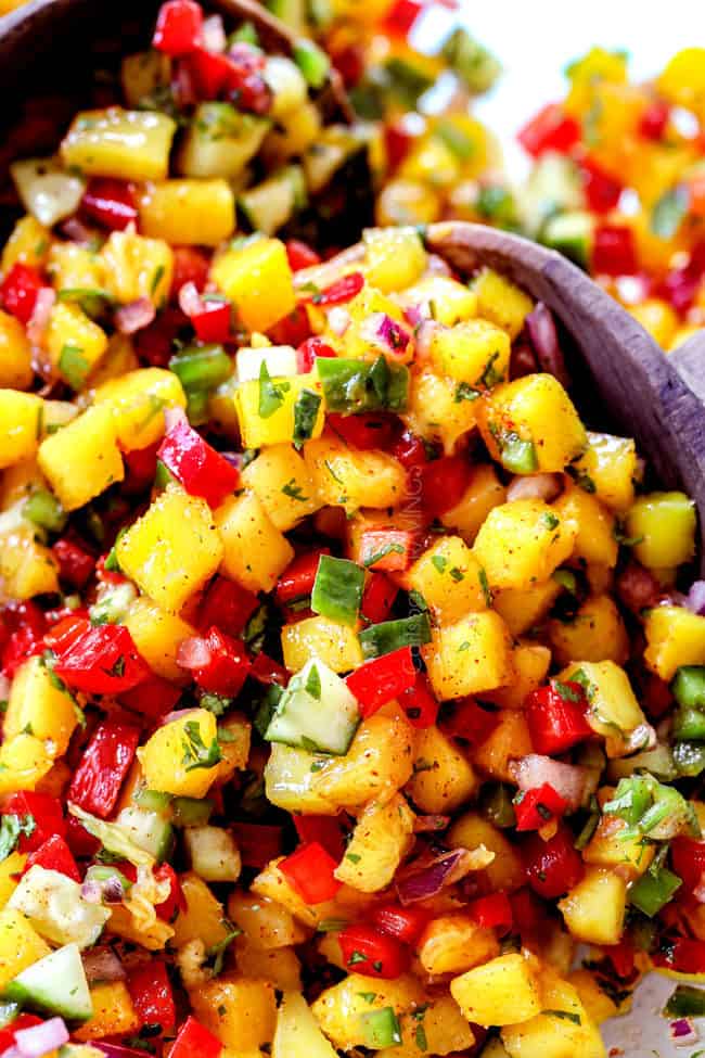 up close of two servings spoons scooping up mango salsa recipe