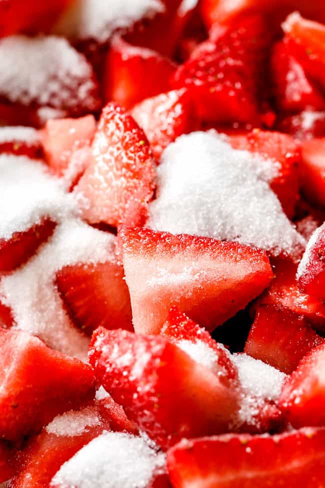 showing how to make strawberry shortcake cake filling by adding sugar to strawberries