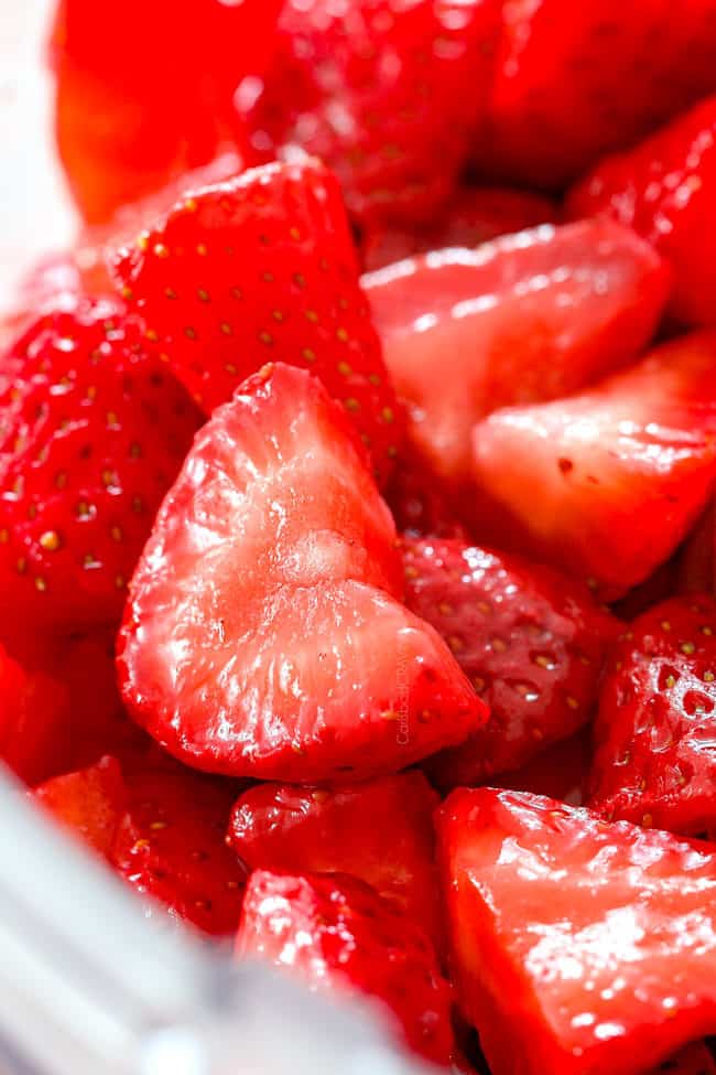 showing how to make strawberry shortcake cake strawberry filling by adding strawberries to a food processor