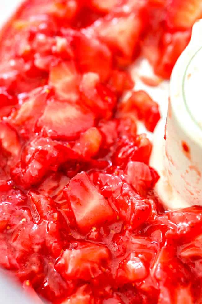 showing how to make strawberry shortcake cake by chopping strawberries in food processor