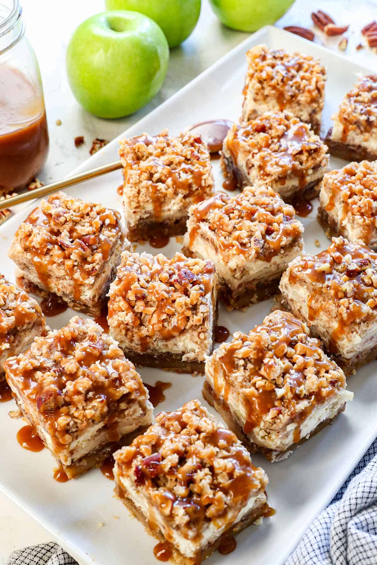 showing how to make apple cheesecake bars by slicing and drizzling with caramel